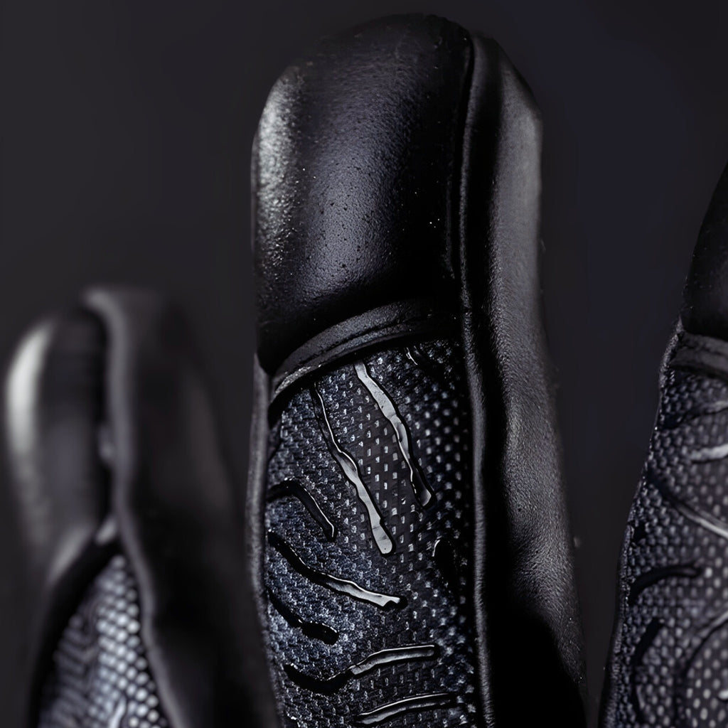 Close-up of N1 Zeus 2.0 Carbon finger detailing the snug Vapor Negative Cut and professional stitching for a second-skin fit.